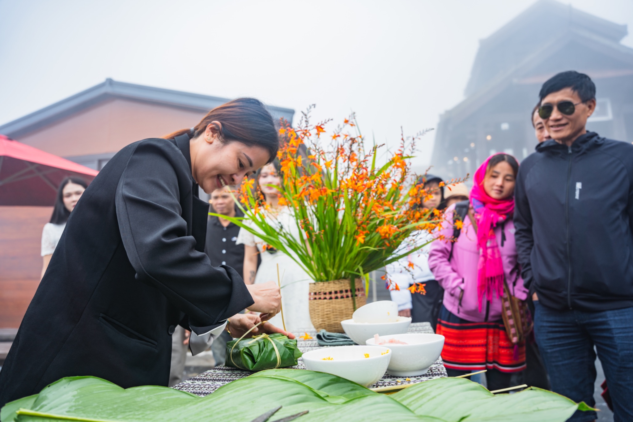 Du khách tham gia thi gói bánh chưng và cắm hoa dơn thóc. 
